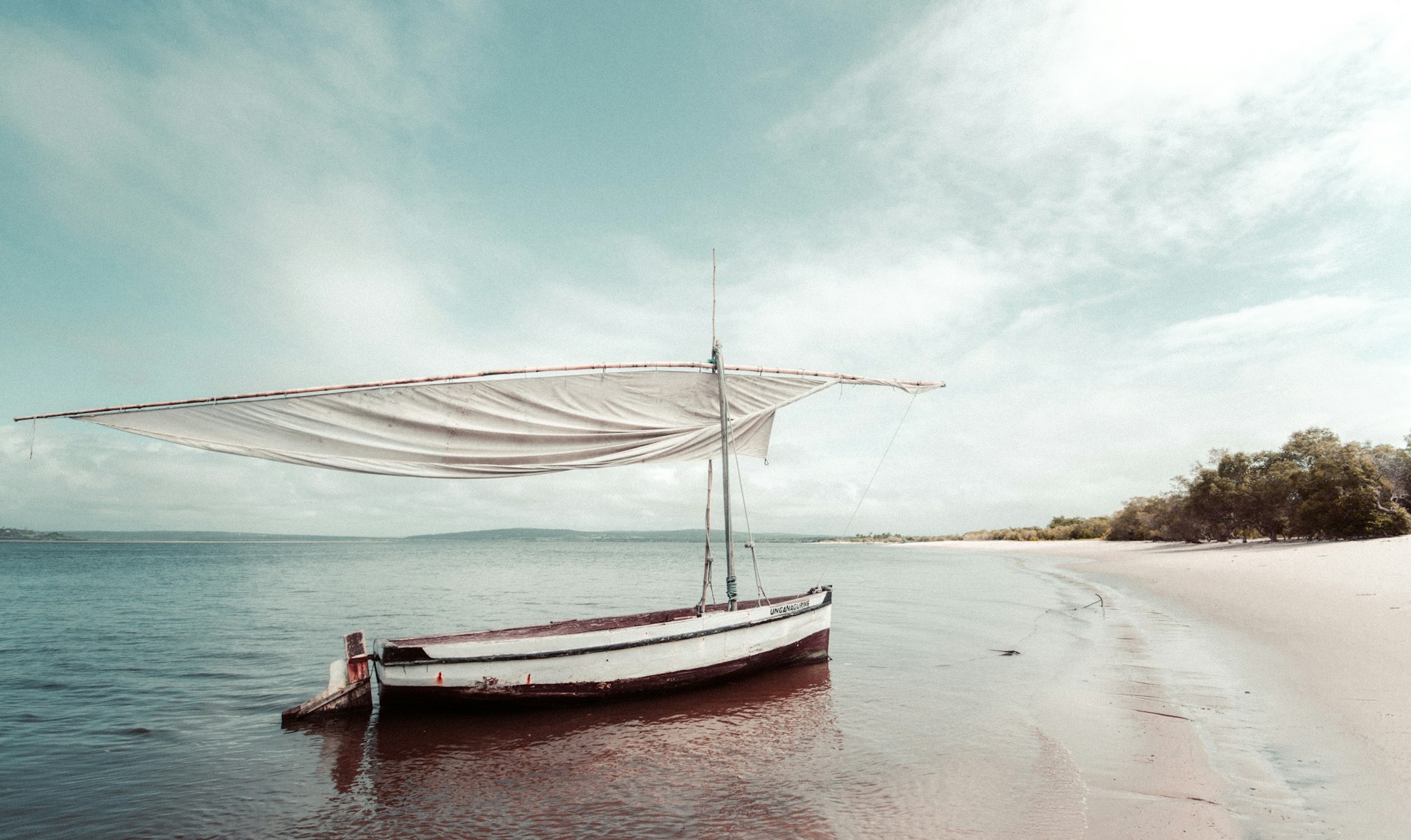 A sailboat at the shore of a calm Mozambican lagoon