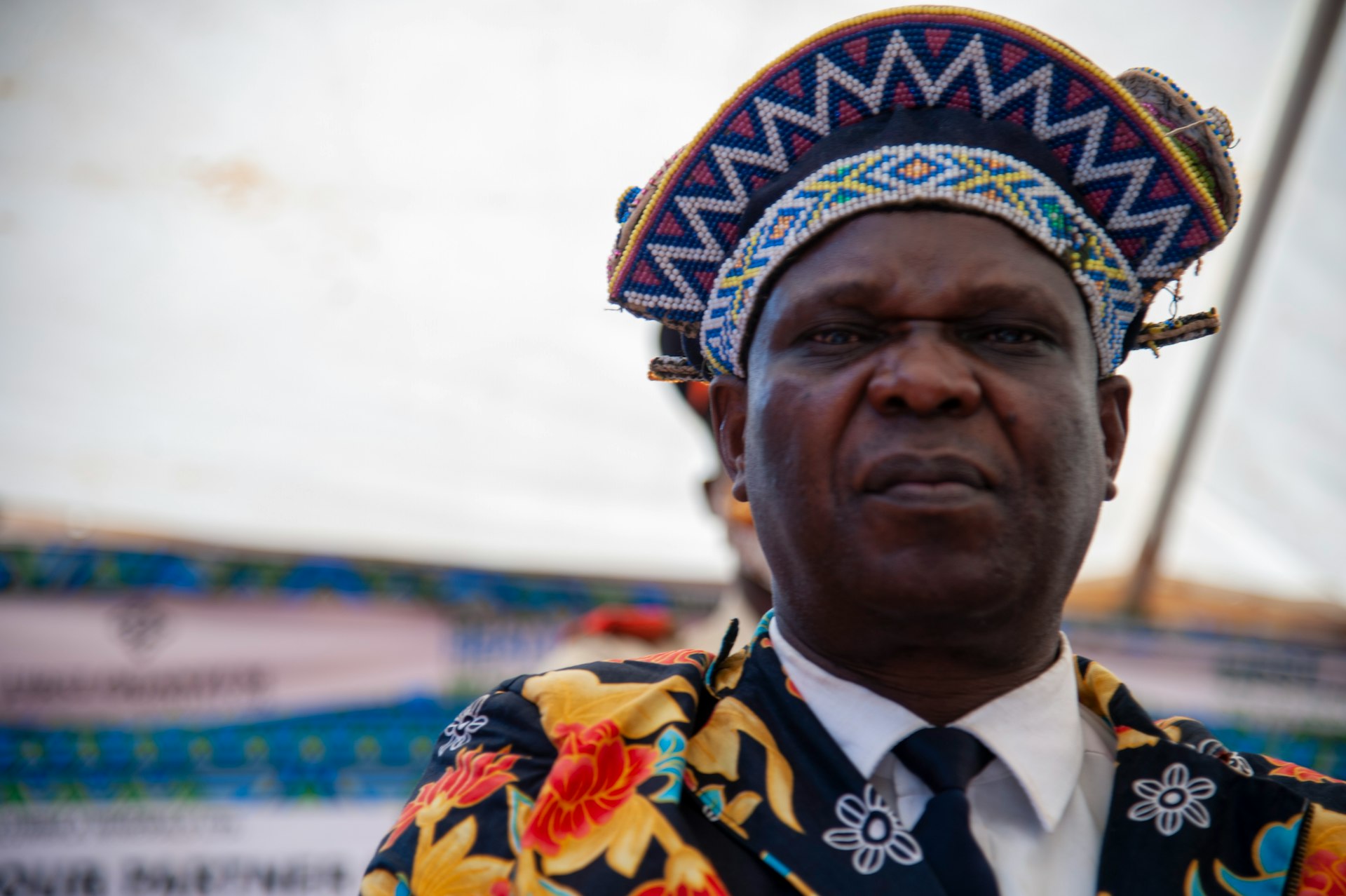 A man in colourful ceremonial headpiece during a Zambian cultural event