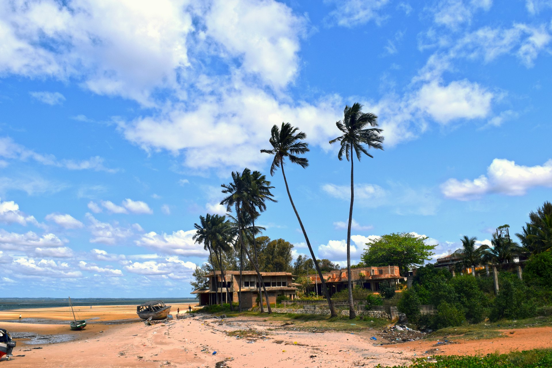 An Inhambane beach with a wooden boat and palm trees