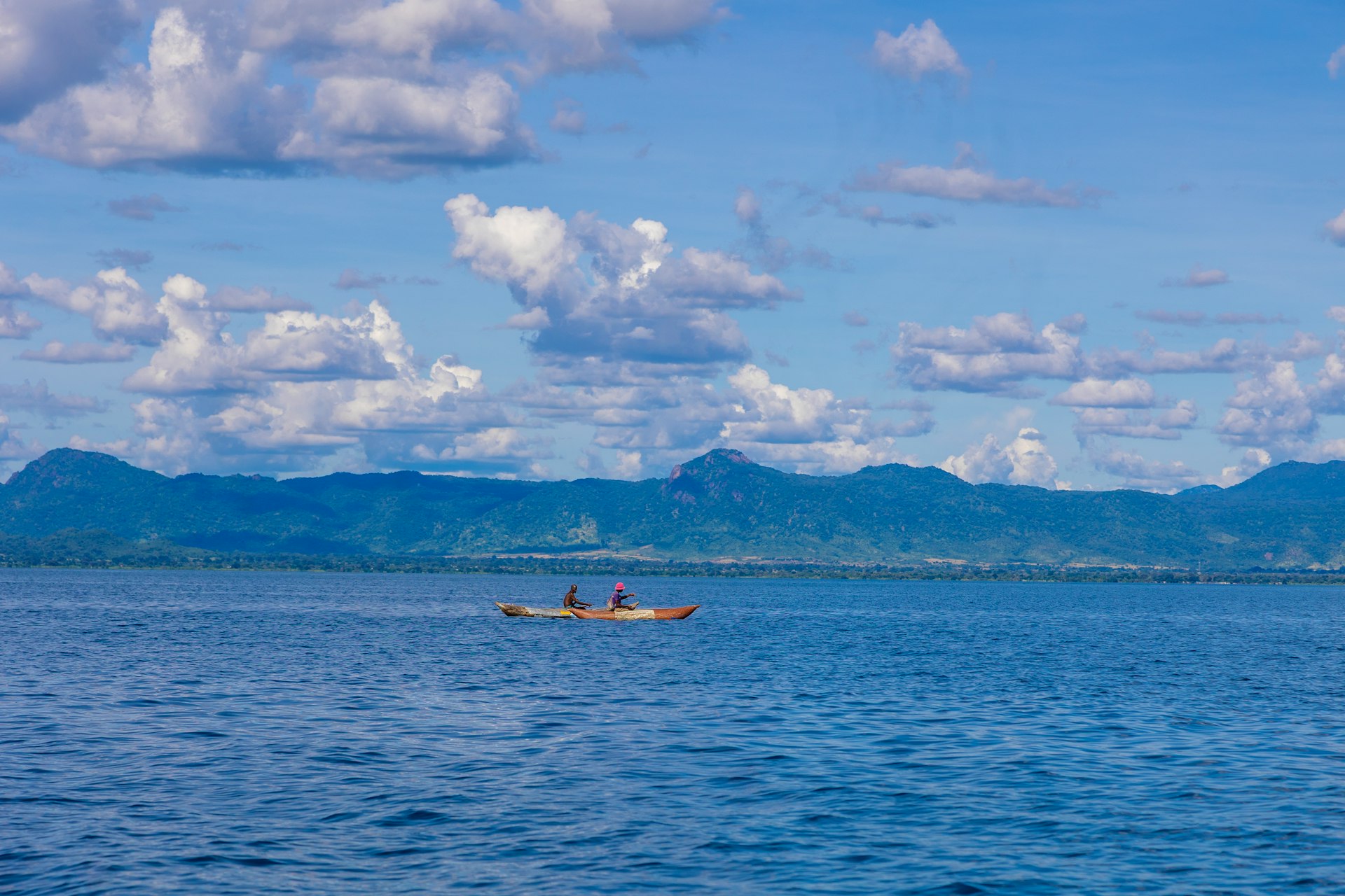 Two people kayaking on the calm blue waters of Lake Malawi